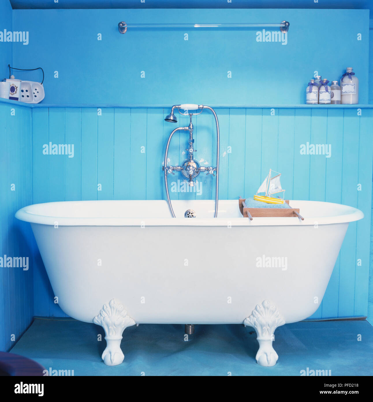 Ornate freestanding bath with shower head fitting in blue bathroom