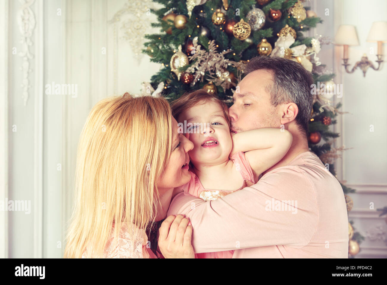 Happy family enjoying life near the Christmas tree Stock Photo - Alamy