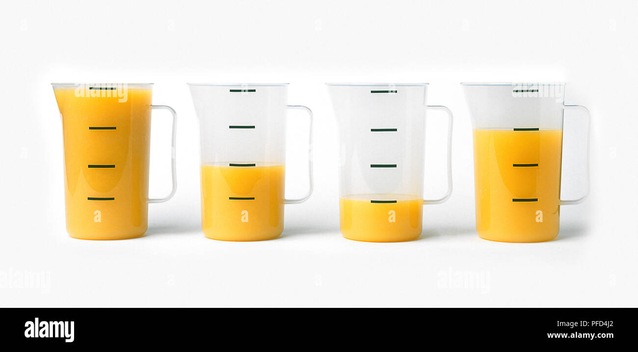 Jugs filled with different quantities of orange juice Stock Photo Alamy