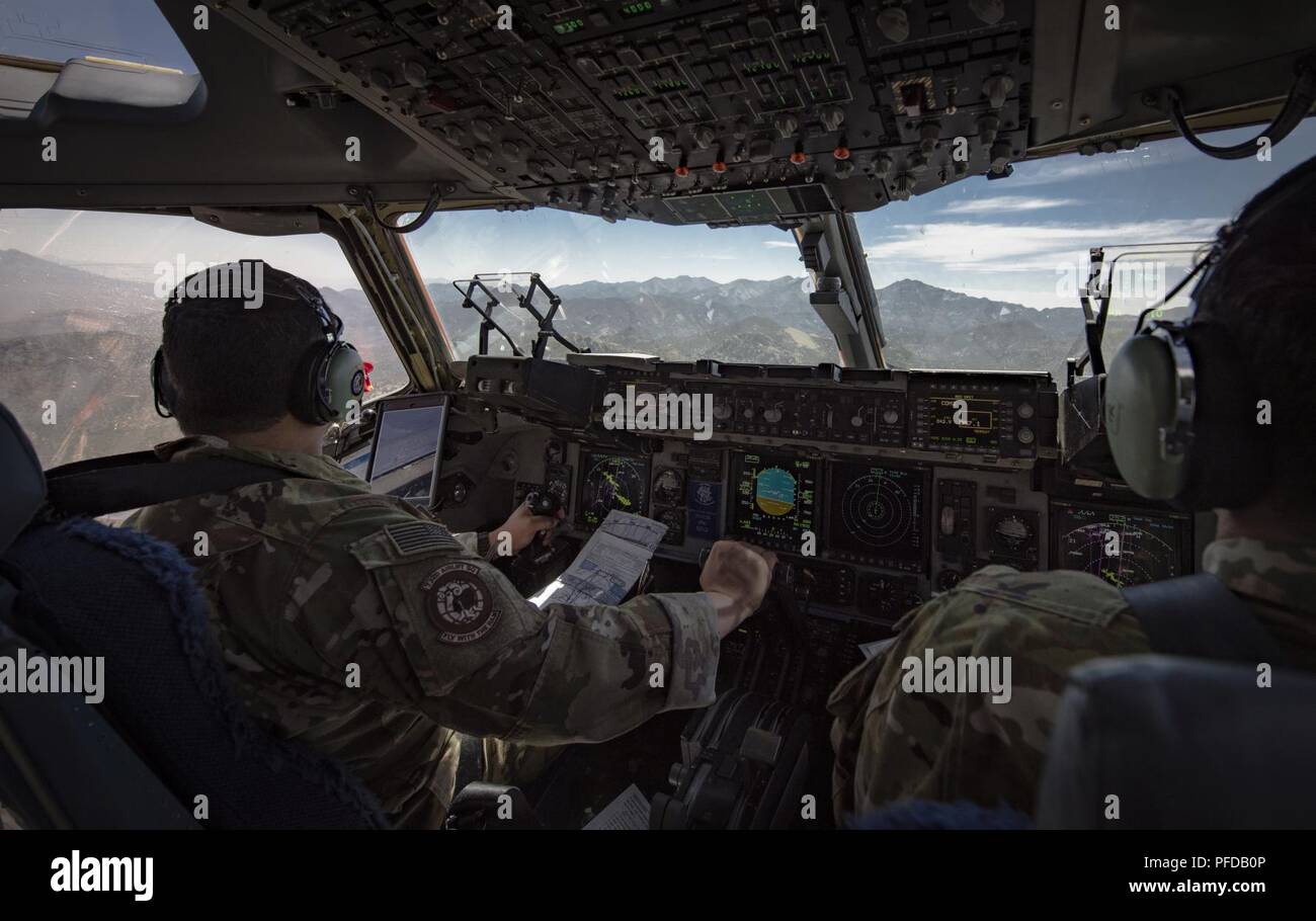 Maj. David Rodriguez, 732nd Airlift Squadron Instructor Pilot, and Capt. Ali Chinisaz, 6th Airlift Squadron instructor pilot, prepare to perform low-altitude, evasive maneuvers in a C-17 Globemaster III cargo aircraft over the Nevada Test and Training Range, June 9, 2018. The C-17 is capable of performing rapid strategic delivery of troops and all types of cargo. Stock Photo