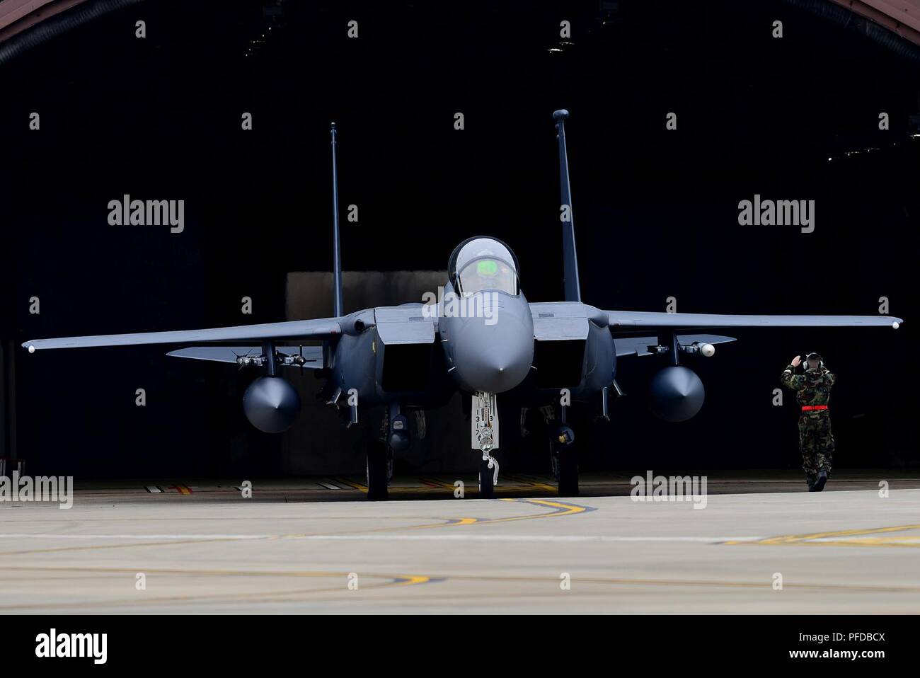A crew chief marshals out an F-15E Strike Eagle assigned to the 492nd Fighter Squadron during a readiness exercise at Royal Air Force Lakenheath, England, June 5, 2018. Exercise scenarios are designed to emphasize the importance of combat skills effectiveness training and ensure Liberty Wing Airmen are fully prepared for potential contingencies. Stock Photo