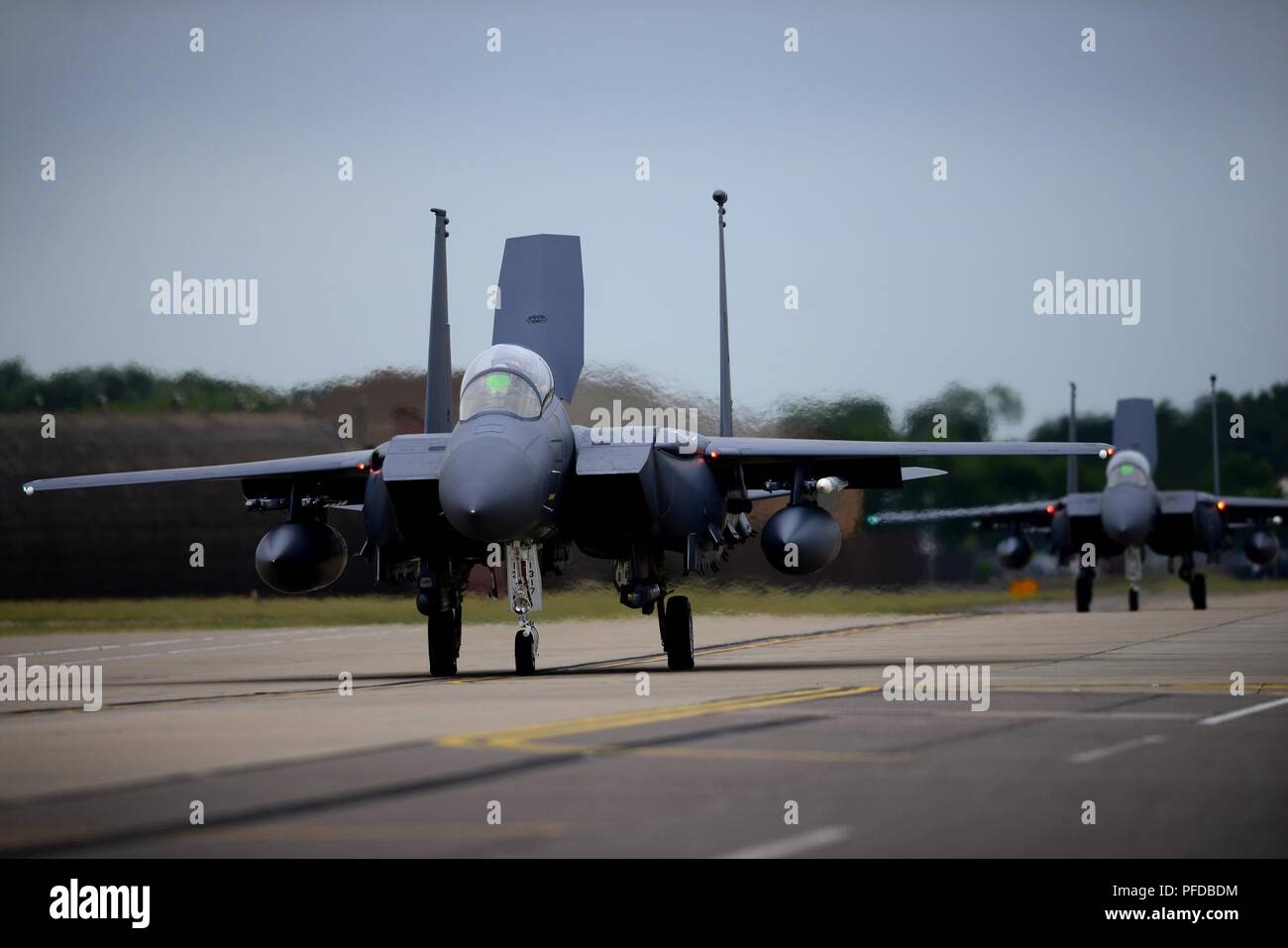 F-15E Strike Eagles assigned to the 492nd Fighter Squadron taxi for the runway during a readiness exercise at Royal Air Force Lakenheath, England, June 5, 2018. Exercise scenarios are designed to emphasize the importance of combat skills effectiveness training and ensure Liberty Wing Airmen are fully prepared for potential contingencies. Stock Photo