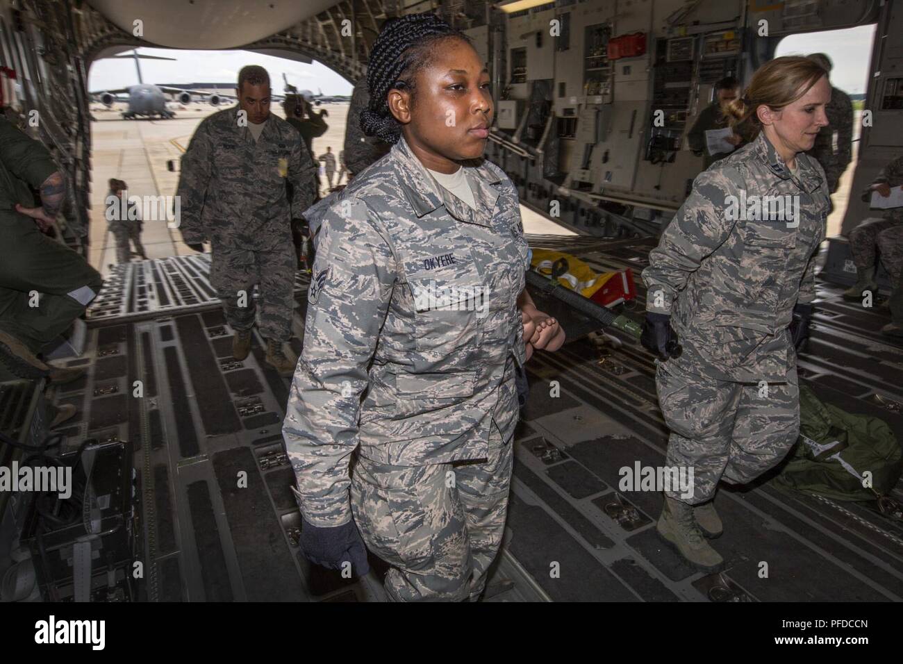 U.S. Air Force Senior Airman Selina N. Okyere, center, 514th Aeromedical Evacuation Squadron, and Capt. Kelly M. Wanamaker, 514th Aeromedical Staging Squadron, both with the 514th Air Mobility Wing, participate in a patient loading exercise at Joint Base McGuire-Dix-Lakehurst, N.J., June 2, 2018. The 514th is an Air Force Reserve Command unit. Stock Photo