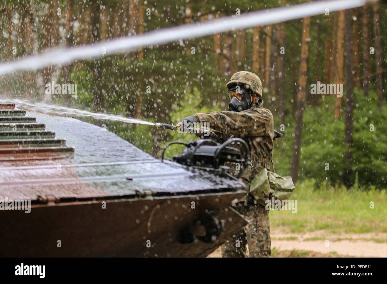 A Polish soldier with 15th Mechanized Brigade, simulates the decontamination of a BWP-1 Infantry Fighting Vehicle as part of Saber Strike 18 with Battle Group Poland at Bemowo Piskie Training Area, Poland on June 5, 2018. Saber Strike is a multinational exercise currently in its eighth year. This year's exercise, which runs from June 3-15, tests allies and partners from 19 countries on their ability work together to deter aggression in the region and improve each unit's ability to perform their designated mission. Stock Photo