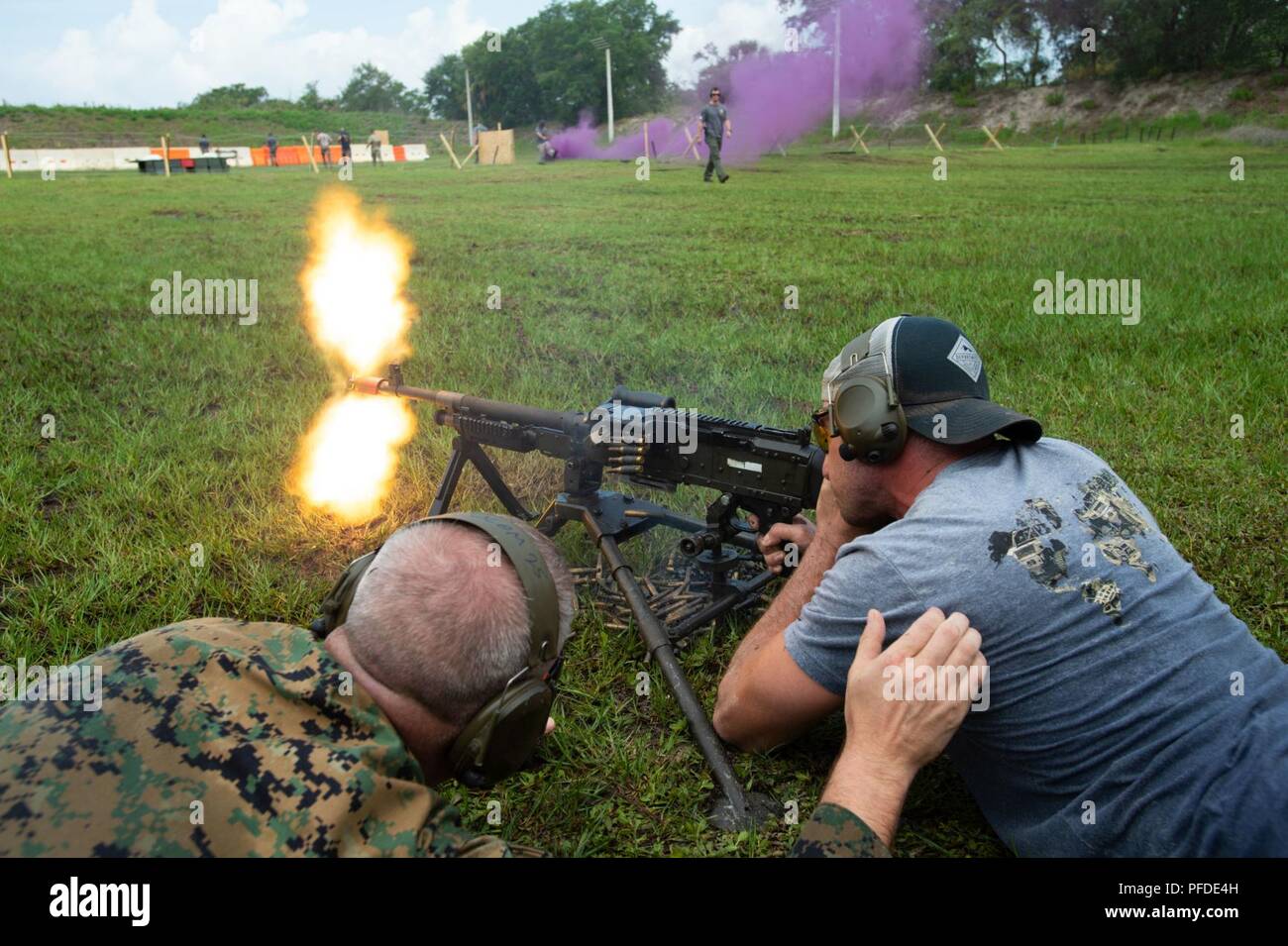 Military and civilian personnel, along with local law enforcement, fire blanks from an M240B machine gun during the U.S. Special Operations Command D-Day Memorial Shoot on MacDill Air Force Base., Fla., June 1, 2018. USSOCOM hosted the event to honor the brave men that stormed the beach on D-Day, while also building comradery and unit cohesion through shared physical exertion. ( Stock Photo