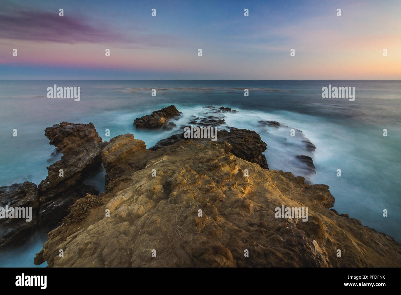 Stunning long-exposure view of smooth waves crashing into rock ...