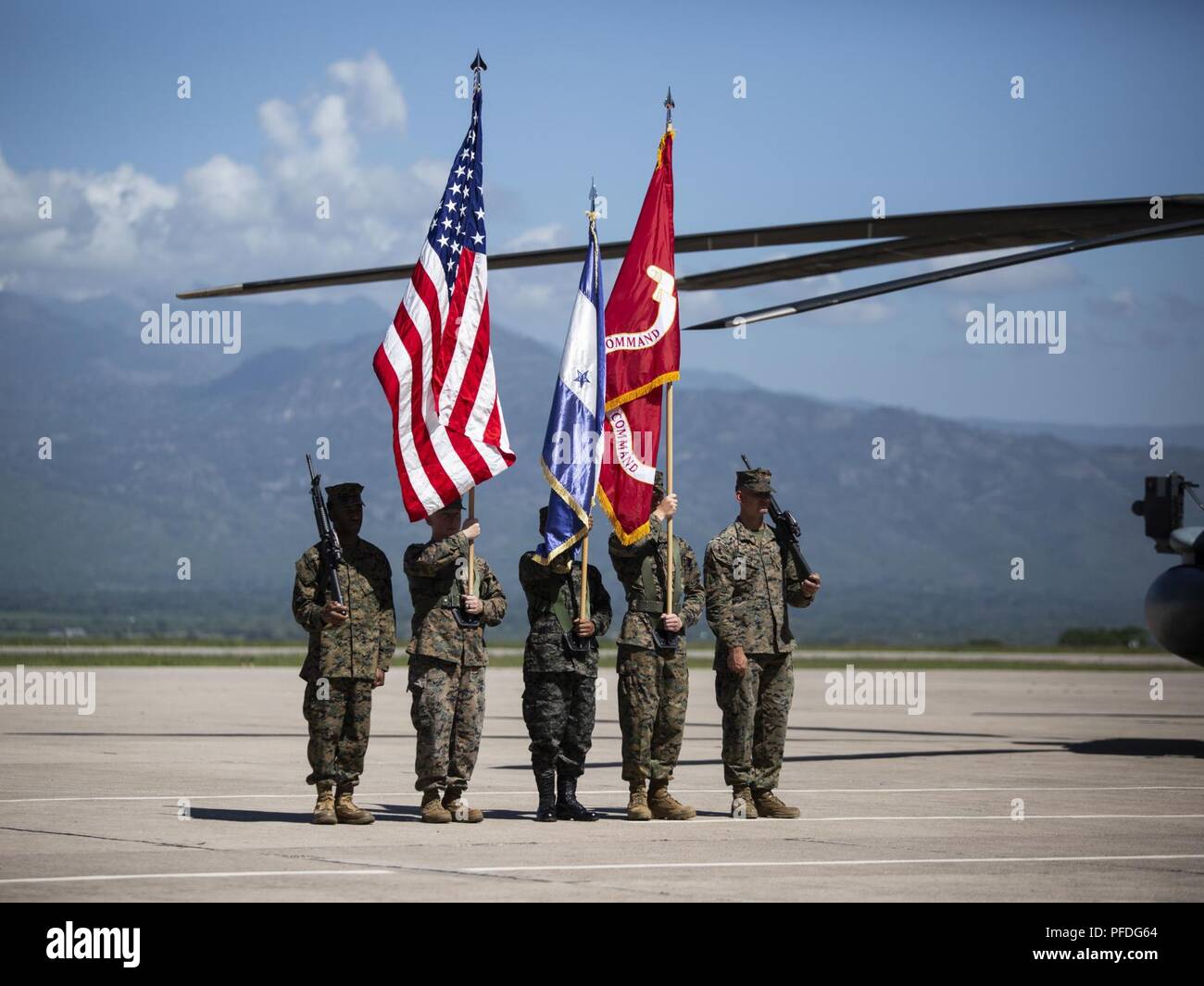 A multinational color guard comprised of Marines with Special Purpose Marine Air-Ground Task Force - Southern Command and a Honduran Army soldier carry colors during an opening ceremony on Soto Cano Air Base, Honduras, to mark the beginning of SPMAGTF-SC deployment to Latin America and the Caribbean, June 11, 2018. The Marines and sailors of SPMAGTF-SC will conduct security cooperation training and engineering projects alongside partner nation military forces in Central and South America during their deployment. The unit is also on standby to provide humanitarian assistance and disaster relief Stock Photo