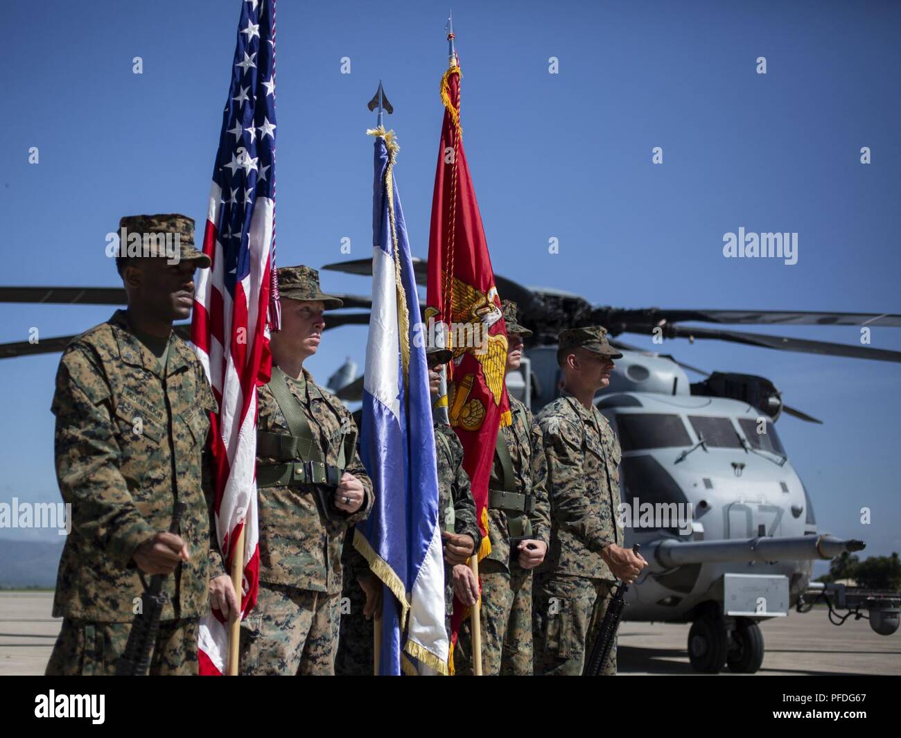 A multinational color guard comprised of Marines with Special Purpose Marine Air-Ground Task Force - Southern Command and a Honduran Army soldier stand at ease during an opening ceremony on Soto Cano Air Base, Honduras, to mark the beginning of SPMAGTF-SC deployment to Latin America and the Caribbean, June 11, 2018. The Marines and sailors of SPMAGTF-SC will conduct security cooperation training and engineering projects alongside partner nation military forces in Central and South America during their deployment. The unit is also on standby to provide humanitarian assistance and disaster relie Stock Photo