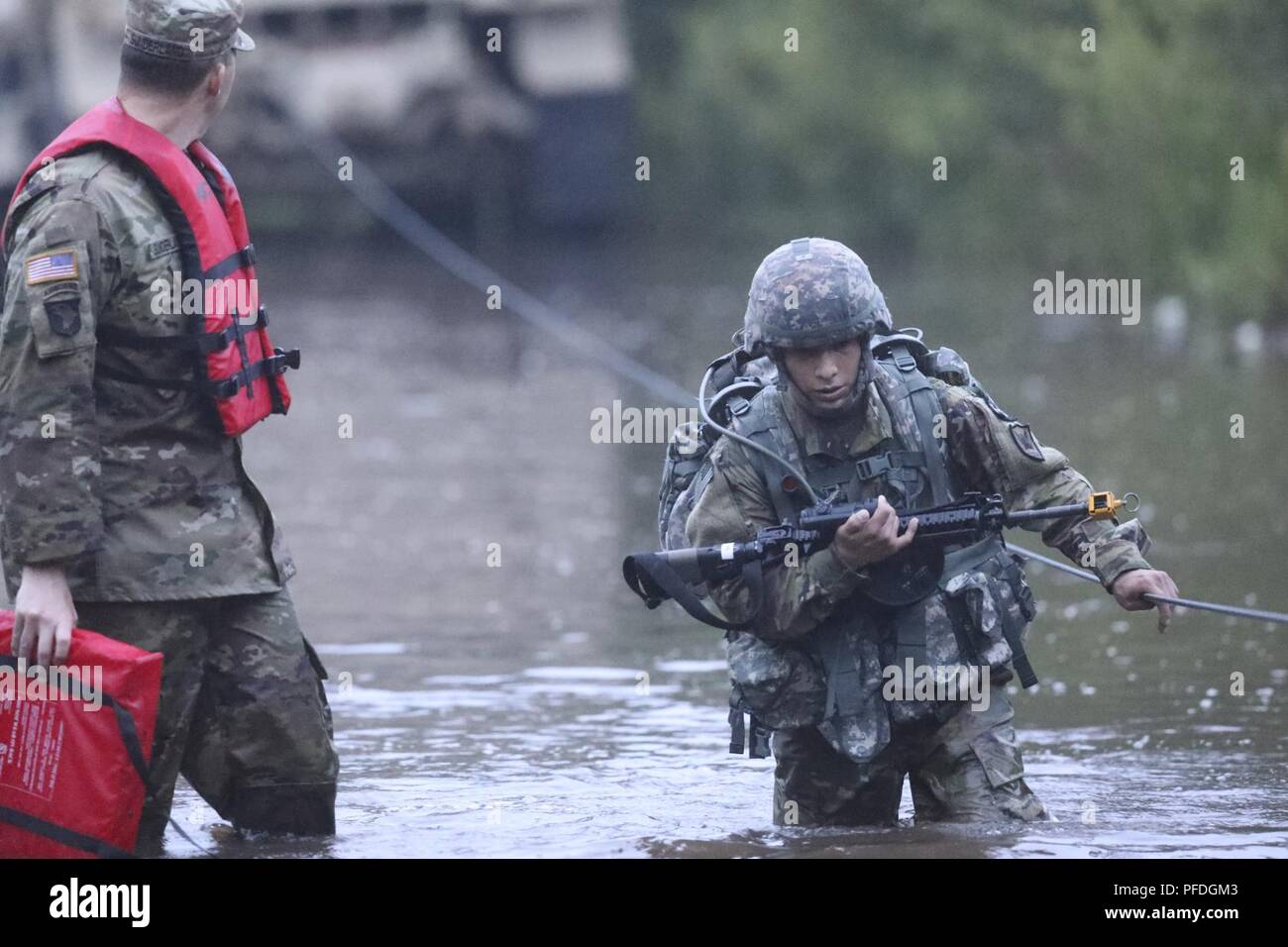 U.S. Army Reserve Spc. Nicolas Cholula-Lopes, a combat cameraman representing the 311th Signal Command (Theater), crosses water during the ruck march event at the 2018 U.S. Army Reserve Best Warrior Competition at Fort Bragg, North Carolina, June 12, 2018. The grueling, multifaceted competition evaluated U.S. Army Reserve Soldiers in the ruck march, the Excellence in Competition pistol range, the German Armed Forces Proficiency Badge and serveral other events with more challenges to come. Stock Photo