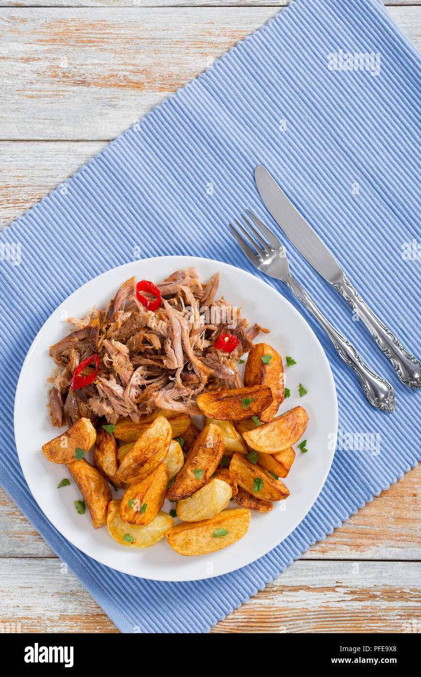 pulled slowcooked pork shoulder grilled in oven with fried potato