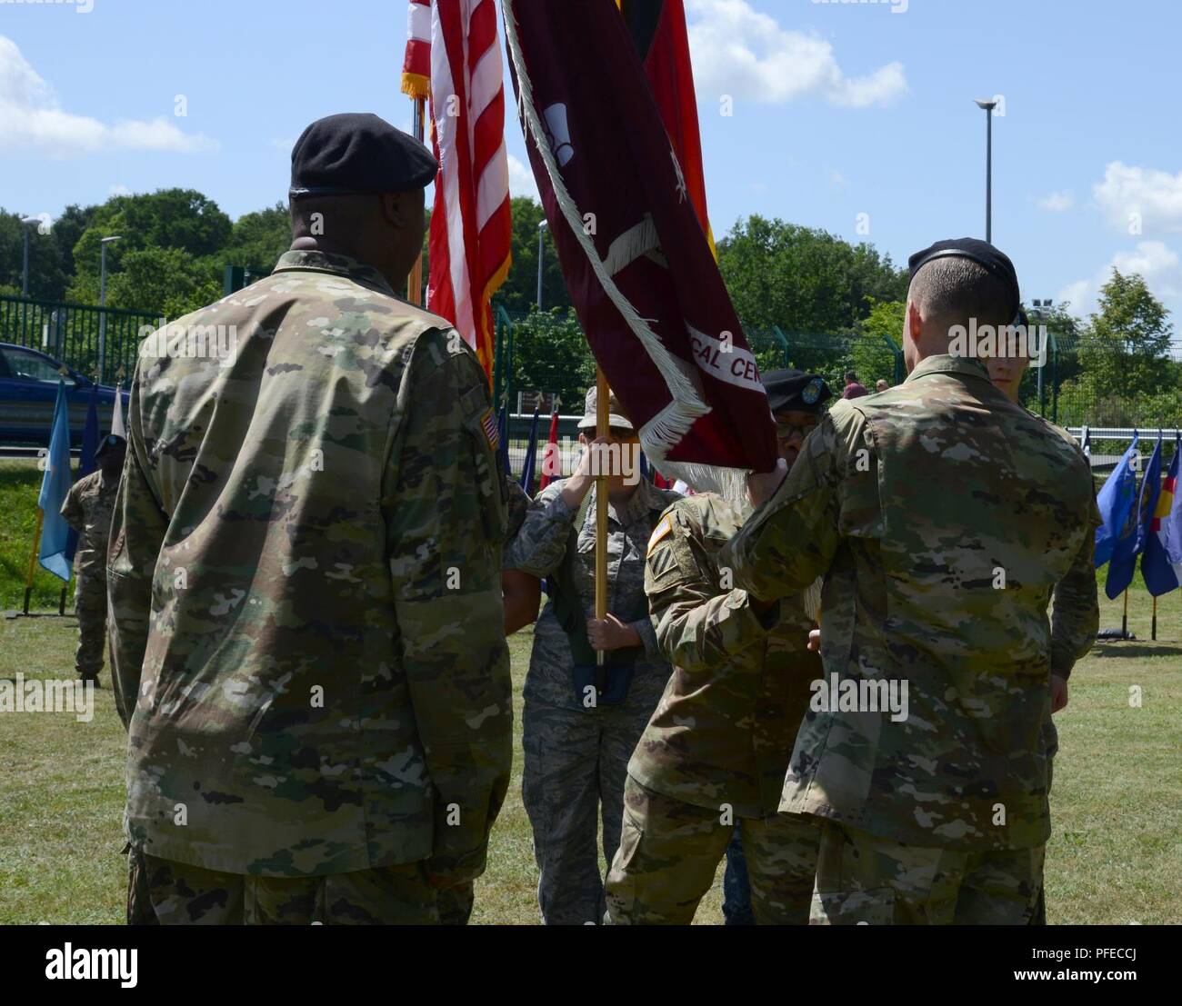 U.S. Army Sgt. First Class Cheryl Mays (center), Landstuhl Regional Medical Center (LRMC) color guard colors sergeant, passes the hospital colors to Command Sgt. Maj. Clark Charpentier (right) during his relinquishment of responsibility ceremony on May 30, 2018 at Landstuhl/Germany Stock Photo