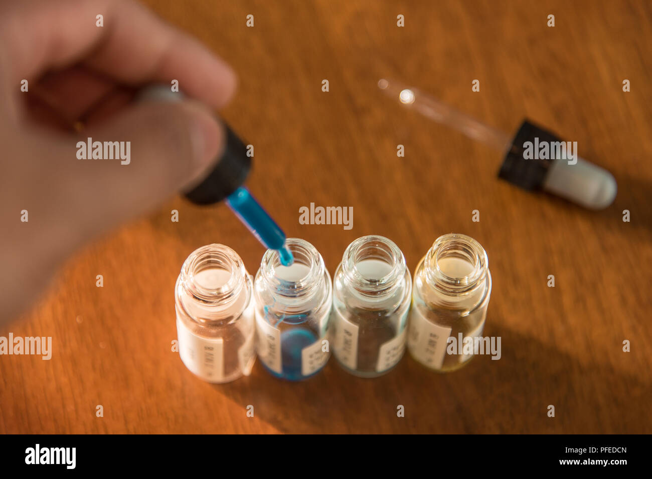 Laboratory glass items adding drop to one of several test tubes. A scientific experiment in a