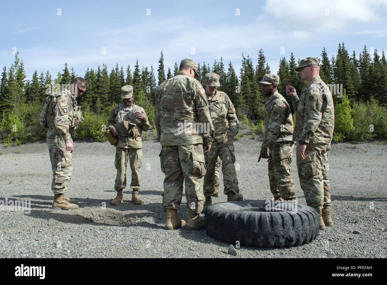 Soldiers assigned to the 109th Transportation Company, 17th Combat Sustainment Support Battalion, U.S. Army Alaska, examine the impacts of an exploded M67 fragmentation grenade after completing live-fire at training at Joint Base Elmendorf-Richardson, Alaska, May 31, 2018. During the familiarization training the Soldiers threw live hand grenades to hone their proficiency. The M67 fragmentation grenade has a lethal radius of 5 meters and can produce casualties up to 15 meters, dispersing shrapnel as far as 230 meters. Stock Photo