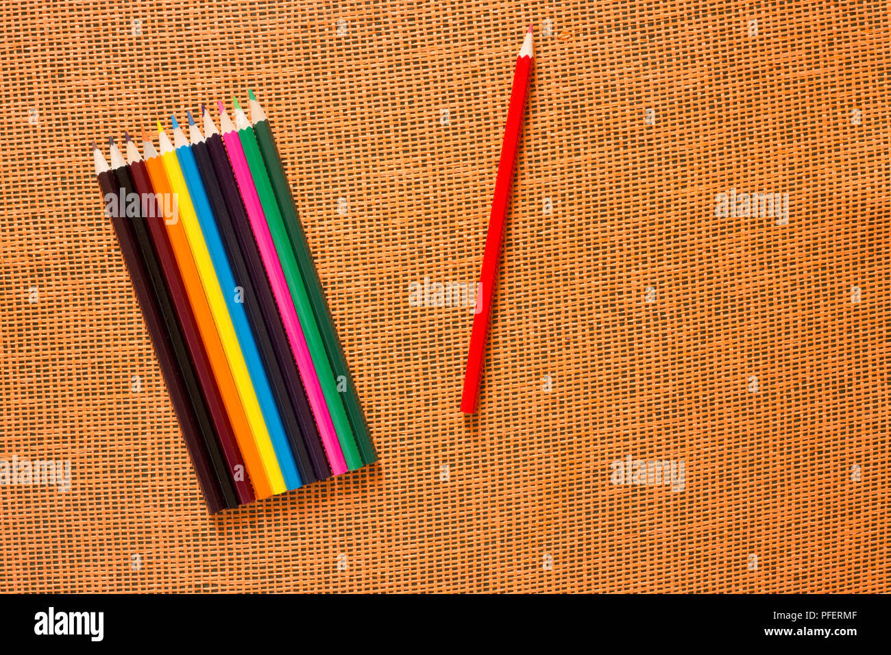 Set of colored pencils on an orange background, top view Stock Photo
