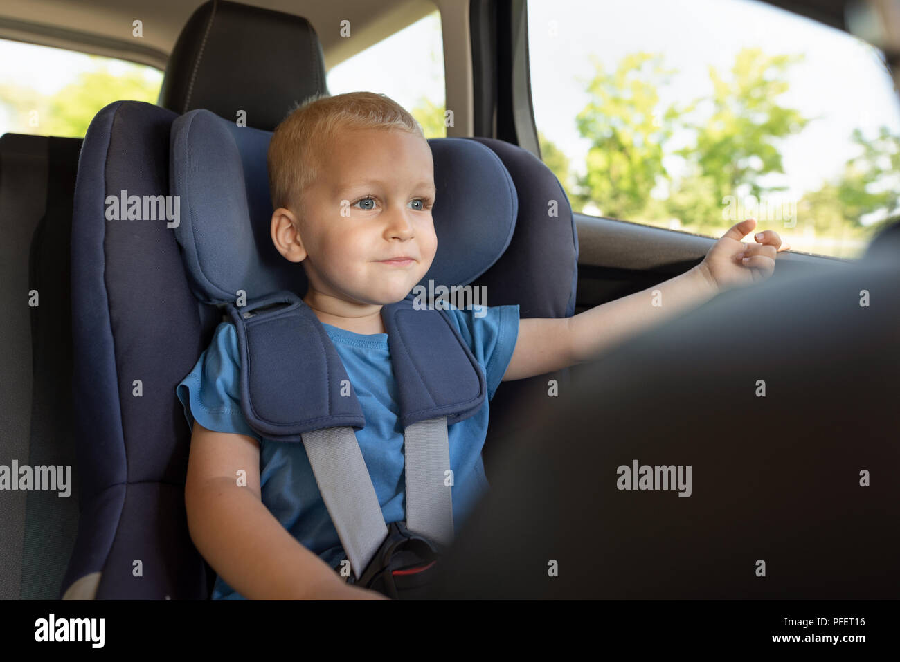 Boy buckled into car seat. Safe family travel concept Stock Photo