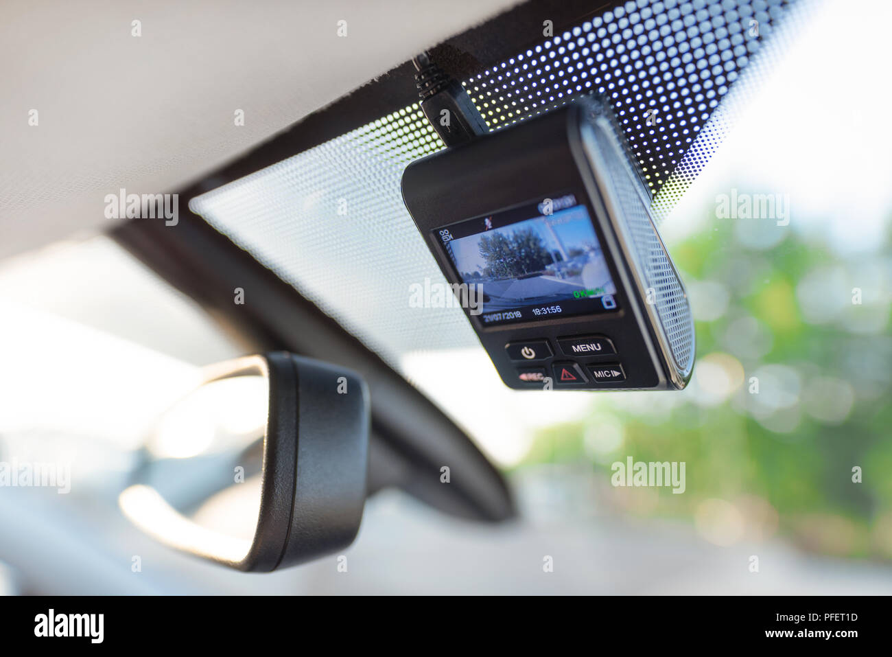 Video recorder next to a rear view mirror. Car camera for safety on the road accident. Stock Photo