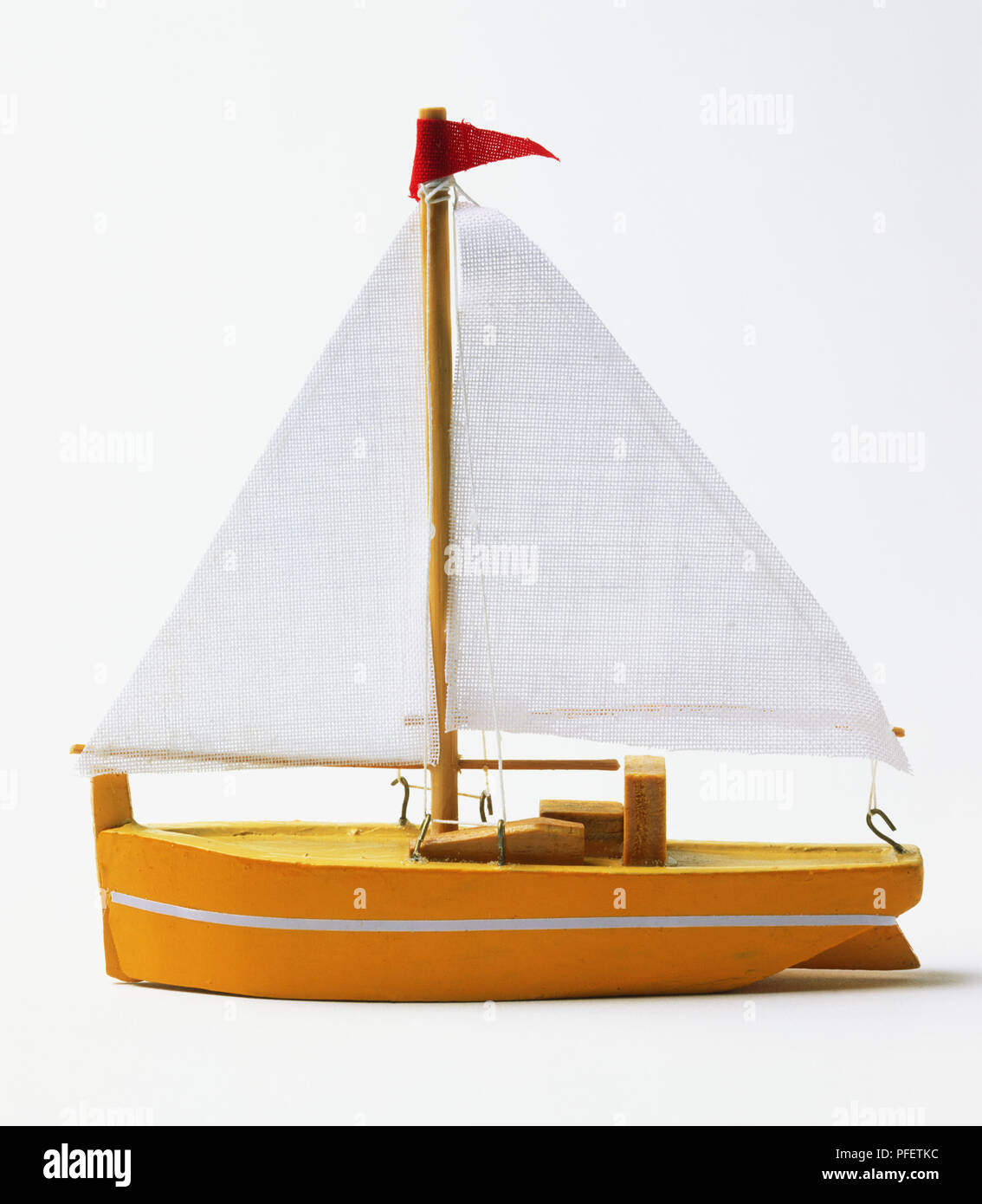 An orange and white toy sailing boat Stock Photo