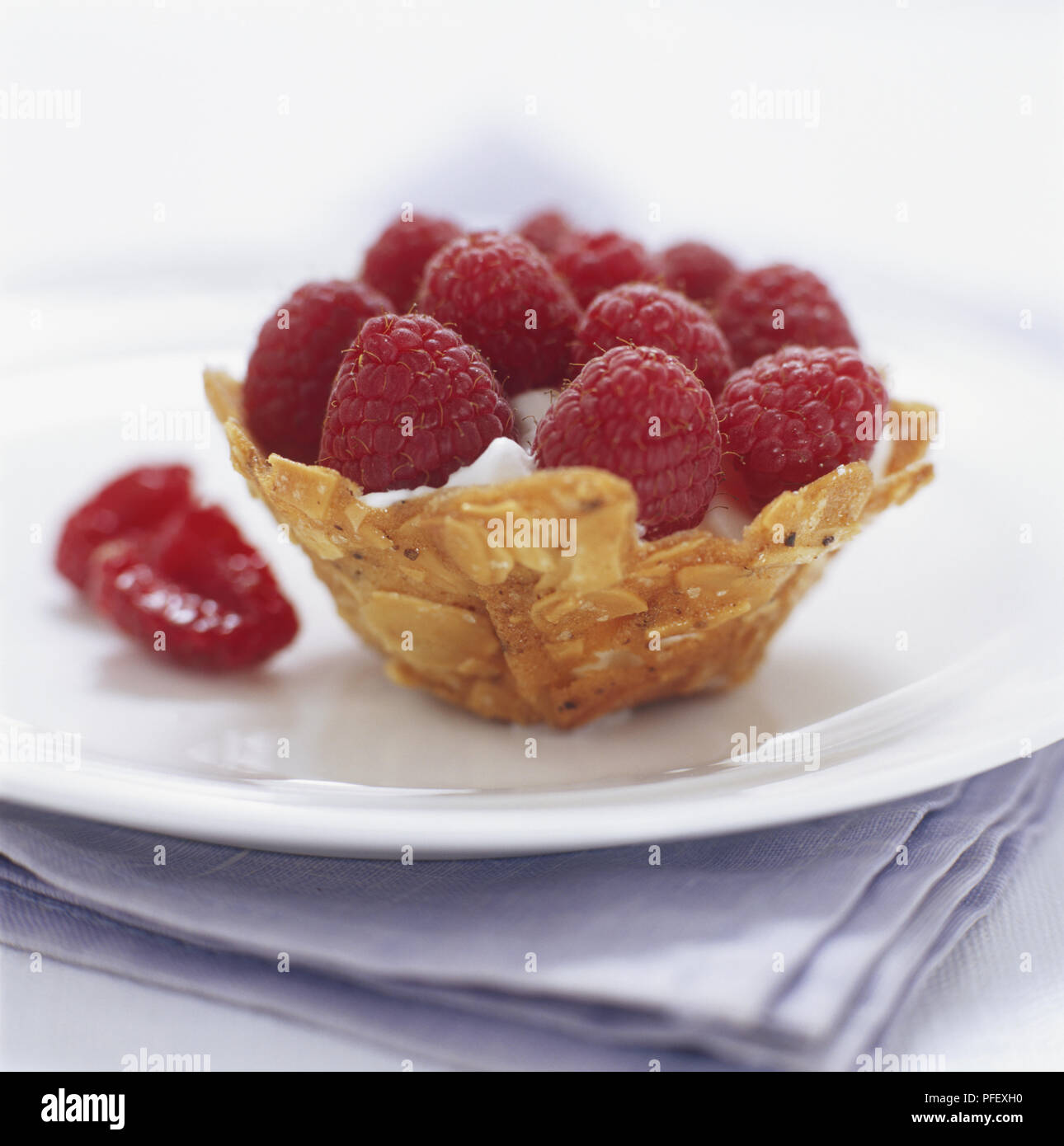 Chantilly tuile baskets, biscuit basket filled with cream and topped with  raspberries, close up Stock Photo - Alamy