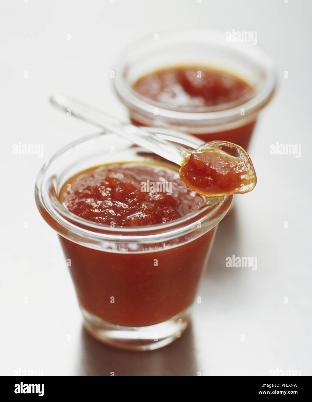 Tomato and horseradish ketchup served in a cup with small spoon, close