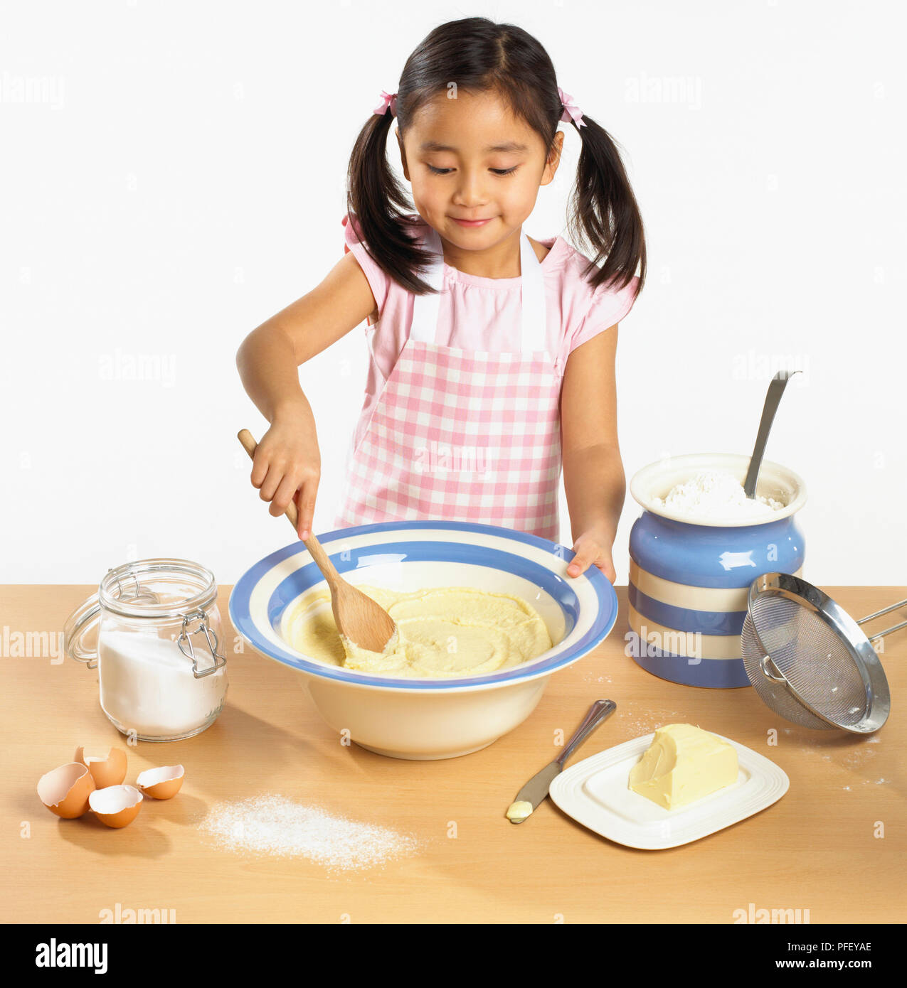 Girl Stirring Mixture In Bowl With Wooden Spoon Stock Photo Alamy
