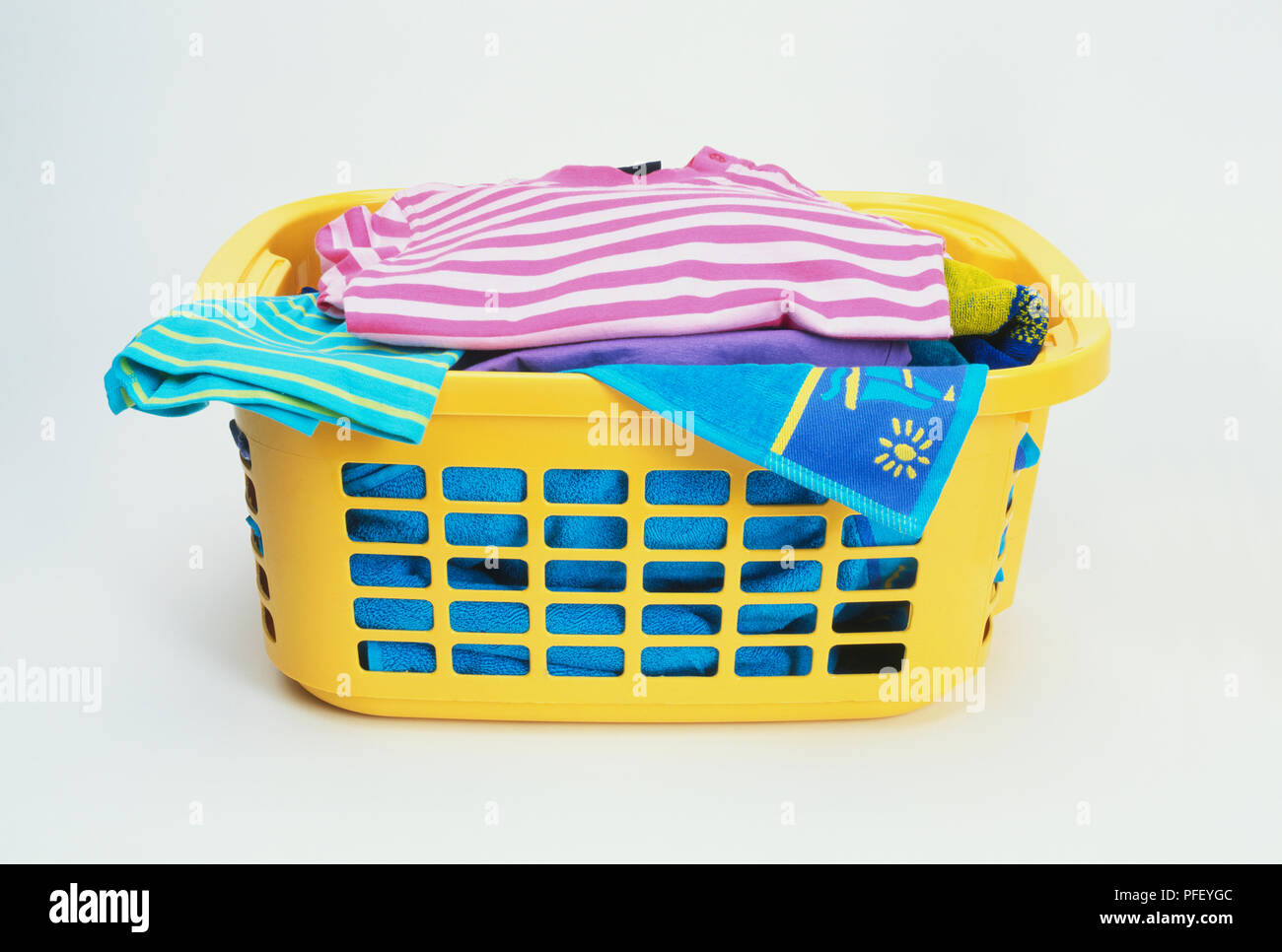 Yellow laundry basket containing towels and clothes Stock Photo Alamy