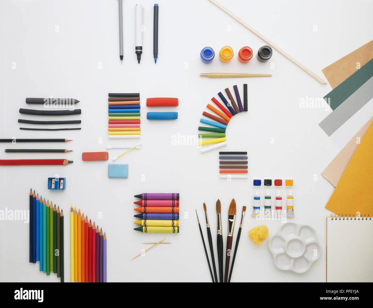 Selection of art materials, including pens, pencils, crayons, pastels, charcoal, paint, paint brushes, paper Stock Photo