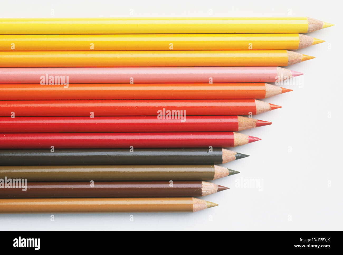 Array of coloured pencils, in shades of brown, red and yellow Stock Photo
