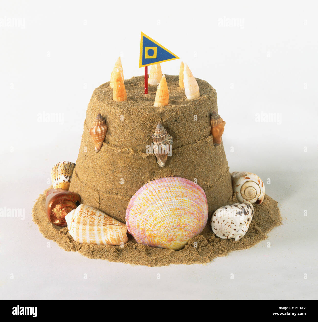 Sandcastle decorated with seashells and flag, side view Stock Photo - Alamy