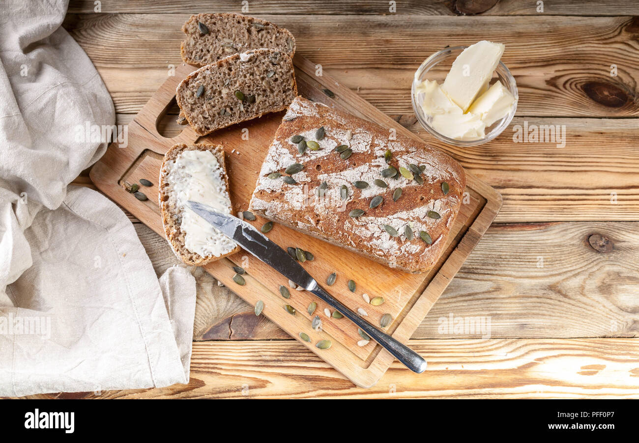 Homemade rye bread with pumpkin seeds and butter. Breakfast concept Stock Photo