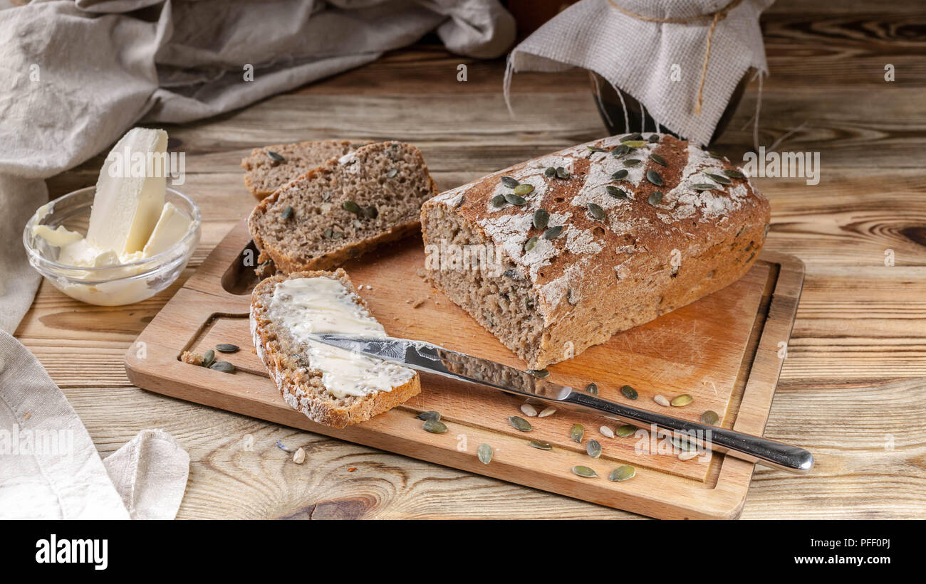 Homemade rye bread with pumpkin seeds and butter. Breakfast concept Stock Photo