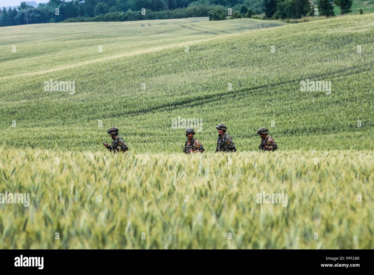 Romanian army soldiers with Air Defense Artillery “Blue Scorpions” Battery, preform reconnaissance on an area during a multinational quick response exercise, Bull Run 5.5, with Battle Group Poland at Olecko, Poland on June 11, 2018 as part of Saber Strike 18. This year's exercise, which runs from June 3-15, tests allies and partners from 19 countries on their ability work together to deter aggression in the region and improve each unit's ability to perform their designated mission. Stock Photo