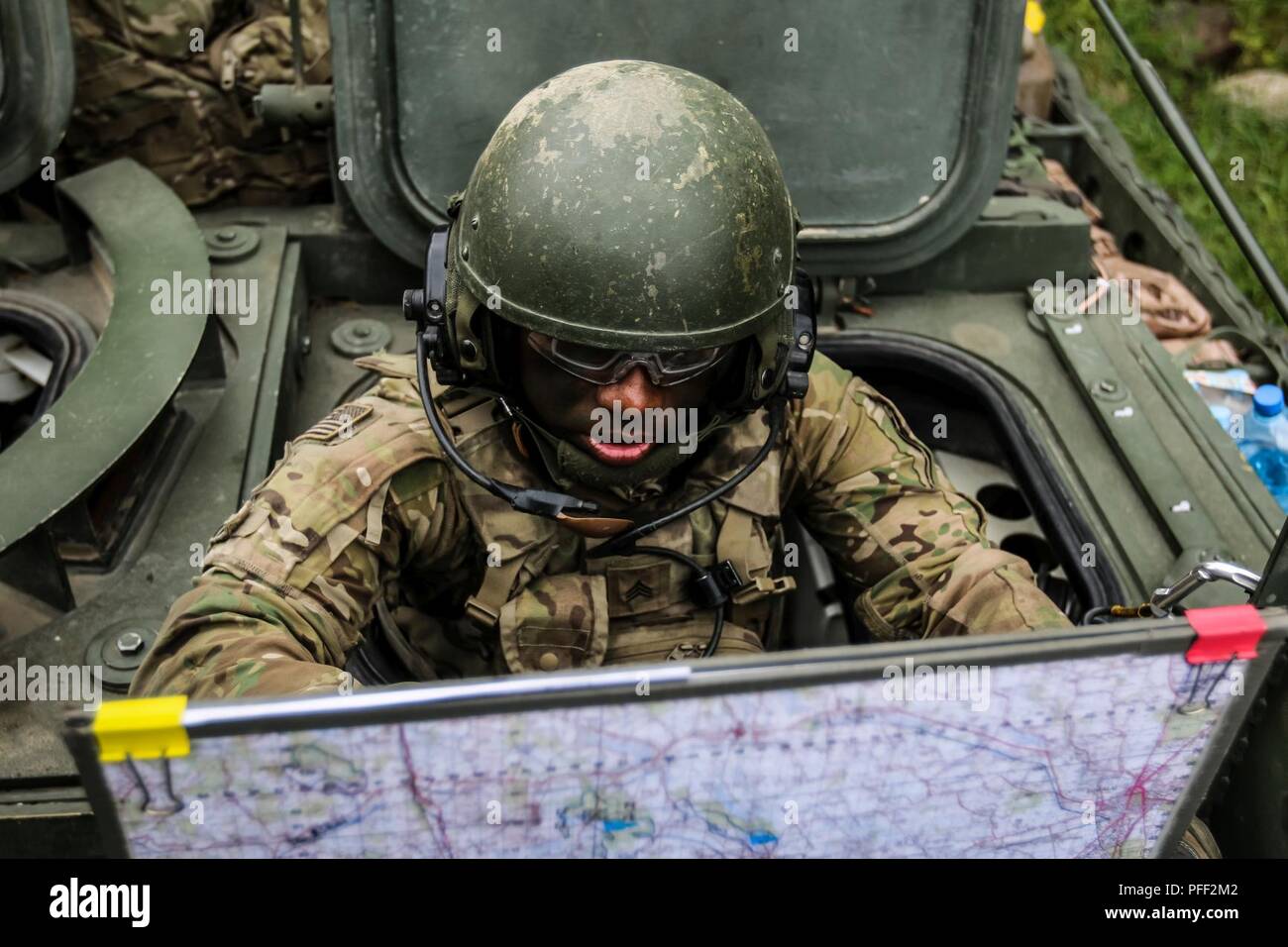 Sgt. Dellon Tobin, Brooklyn, New York native, infantryman with 1st Squadron, 2nd Cavalry Regiment, organizes a troop movement during exercise Puma 2 with Battle Group Poland at Bemowo Piskie Training Area, Poland on June 13, 2018 in the midst of Saber Strike 18. This year's exercise, which runs from June 3-15, tests allies and partners from 19 countries on their ability work together to deter aggression in the region and improve each unit's ability to perform their designated mission. Stock Photo