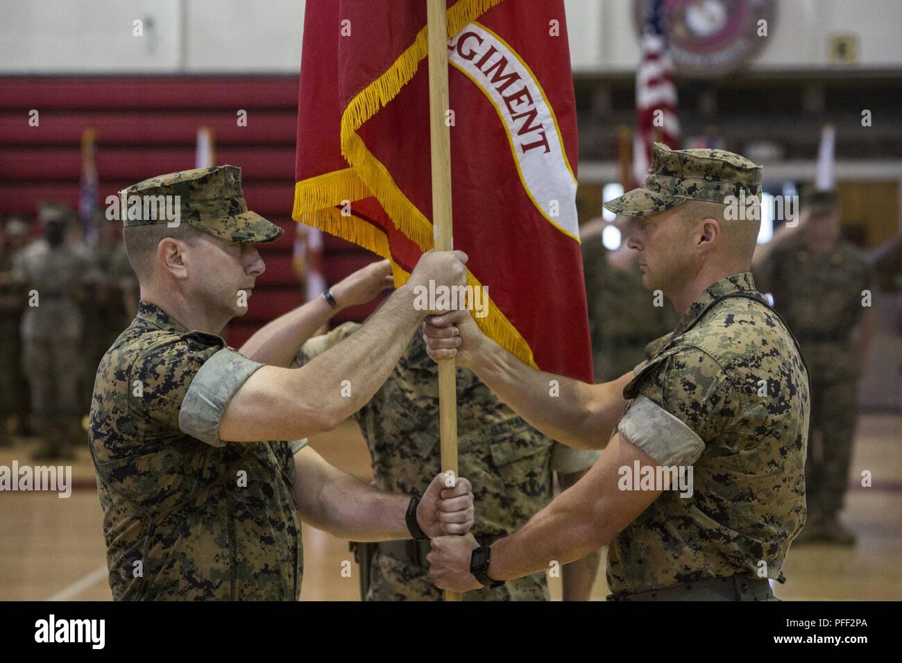 U.S. Marine Corps Col. Daniel T. Canfield Jr., left, the incoming commanding officer of 6th Marine Regiment, receives the unit colors from Col. Matthew S. Reid, right, the outgoing commanding officer of 6th Marine Regiment, 2nd Marine Division, during a change of command ceremony at Camp Lejeune, N.C., June 12, 2018. During the ceremony, Reid relinquished command of the unit to Canfield Jr. Stock Photo