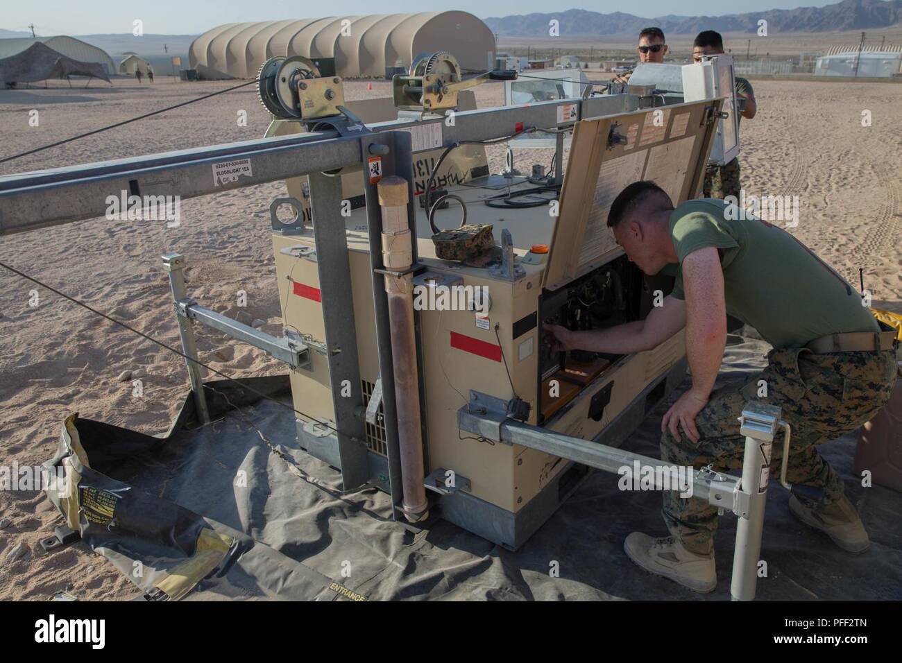 Staff Sgt. Lucas White, an engineer equipment electrical systems technician with Maintenance Company, Combat Logistics Battalion 451, Combat Logistics Regiment 45, 4th Marine Logistics Group, Lance Cpl. Eli Sommers, a refrigeration and air conditioning technician with Utilities, CLR-45, 4th MLG, and Private First Class Sergio Gonzalez, a motor vehicle operator with CLB-451, CLR-45, 4th MLG, set up a floodlight during Integrated Training Exercise 4-18 at Marine Corps Air Ground Combat Center Twentynine Palms, California, June 12, 2018. Marines with the Exercise Support Element of ITX 4-18 provi Stock Photo