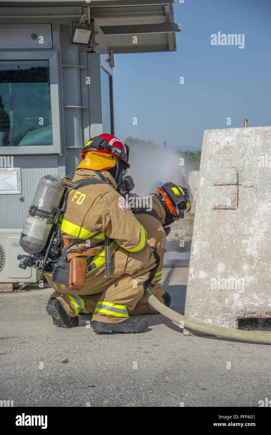 NAVAL SUPPORT ACTIVITY SOUDA BAY, Greece (June 12, 2018) Firefighters assigned to Naval Support Activity Souda Bay, Greece, spray water from a fire hose during a forward lay skill evaluation drill, June 12, 2018, at Naval Support Activity (NSA) Souda Bay, Greece. NSA Souda Bay recently participated in various scenarios that simulated command-level and tactical decision-making that were evaluated by a Regional Training Team as part of an Operational Readiness Assessment. Stock Photo