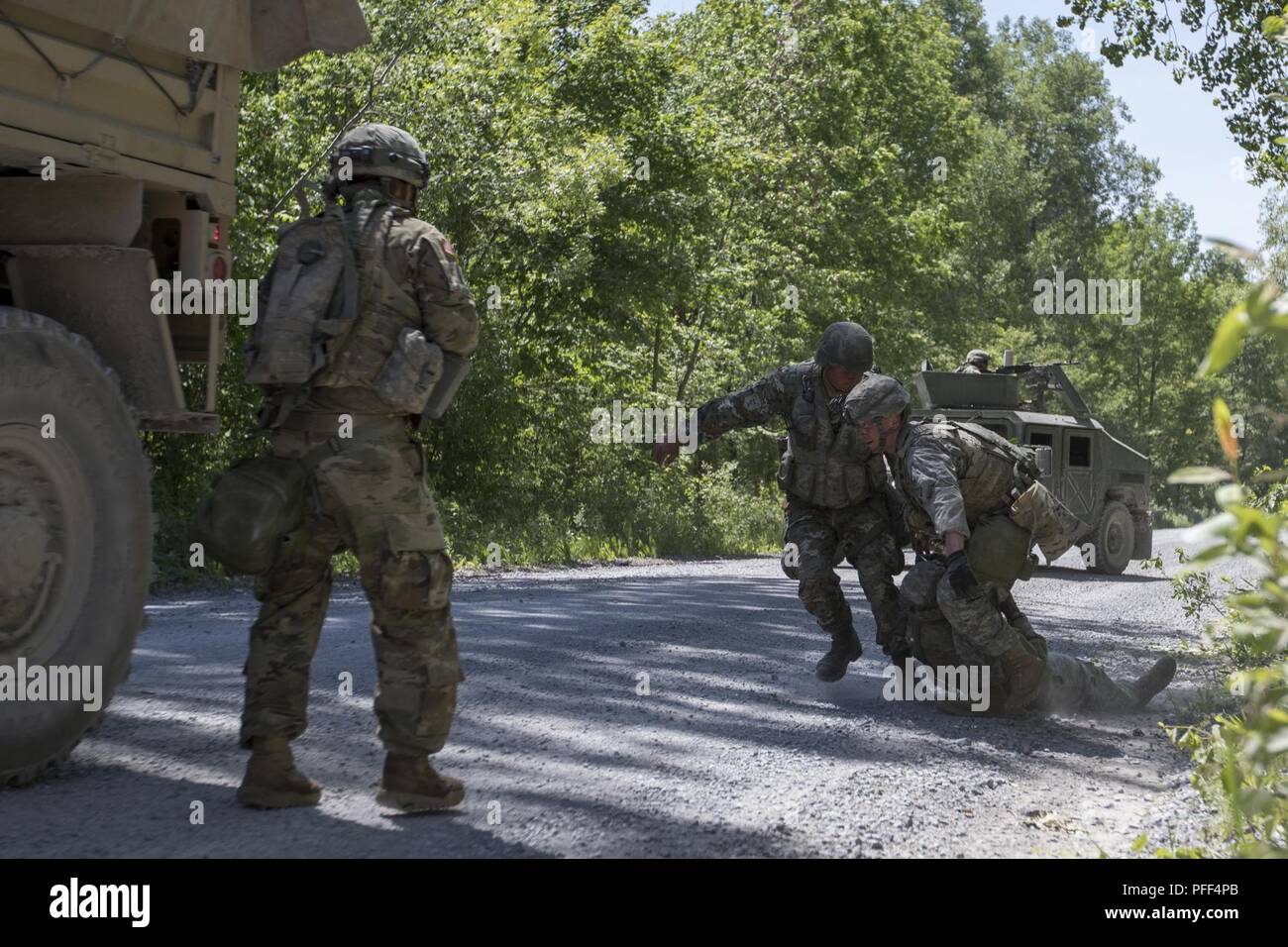 A U.S. Soldier and a Macedonian Soldier pull a Soldier to safety during a  simulated attack during route clearance training at Fort Drum, N.Y., June  12. The route clearance training was conducted