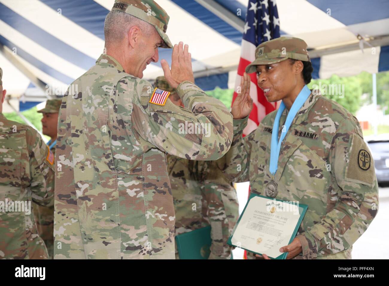 Staff Sgt. April Thomas, assigned to Public Health Activity Japan, salutes Maj. Gen. James F. Pasquarette, commanding general of USARJ after receiving an Audie Murphy induction award June 13, 2018 outside the Camp Zama Community Club for the Army Birthday Week celebration. Stock Photo