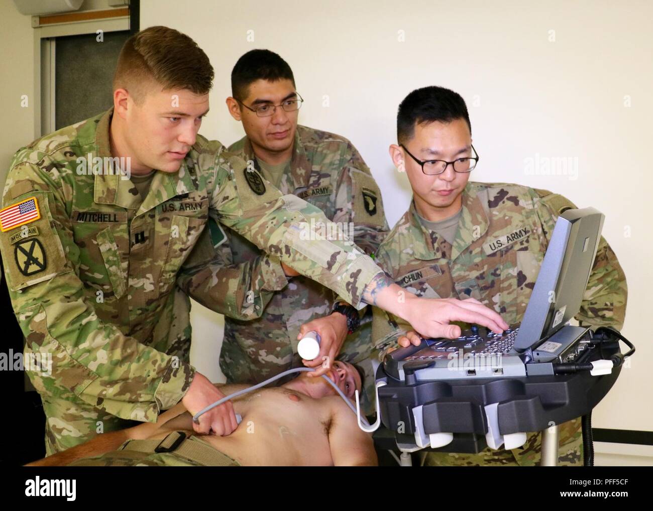 Interservice Physician Assistant Program Phase II student Capt. Dakota Mitchell, assigned to Blanchfield, shows combat medic specialist, Spc. Joshua Huante, assigned to 1st Battalion, 187th Infantry Regiment, 3rd Brigade Combat Team, 101st Airborne Division, and patient administration specialist, Spc. Wooyoung Chun, assigned to 626th Brigade Support Battalion, 3rd Brigade Combat Team, 101st Airborne Division how to operate an ultrasound machine on fellow IPAP Phase II student Capt. Zachary Quigg. IPAP Phase II students are assigned to Blanchfield for 13 months to complete clinical rotations. T Stock Photo