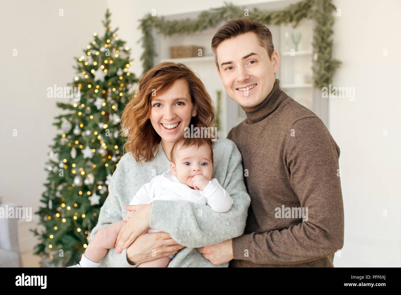 Parents and baby near Christmas tree Stock Photo