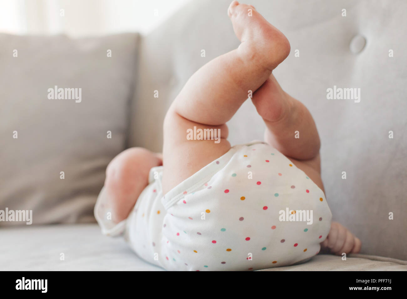 Anonymous baby lying on couch Stock Photo