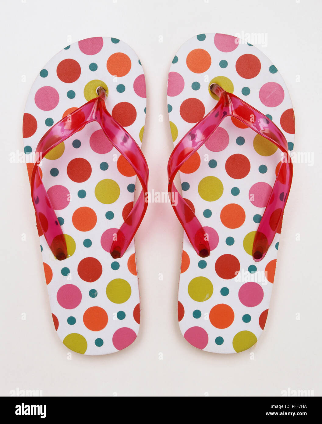 A pair of flip-flops with pink plastic bands and dotted soles. Stock Photo