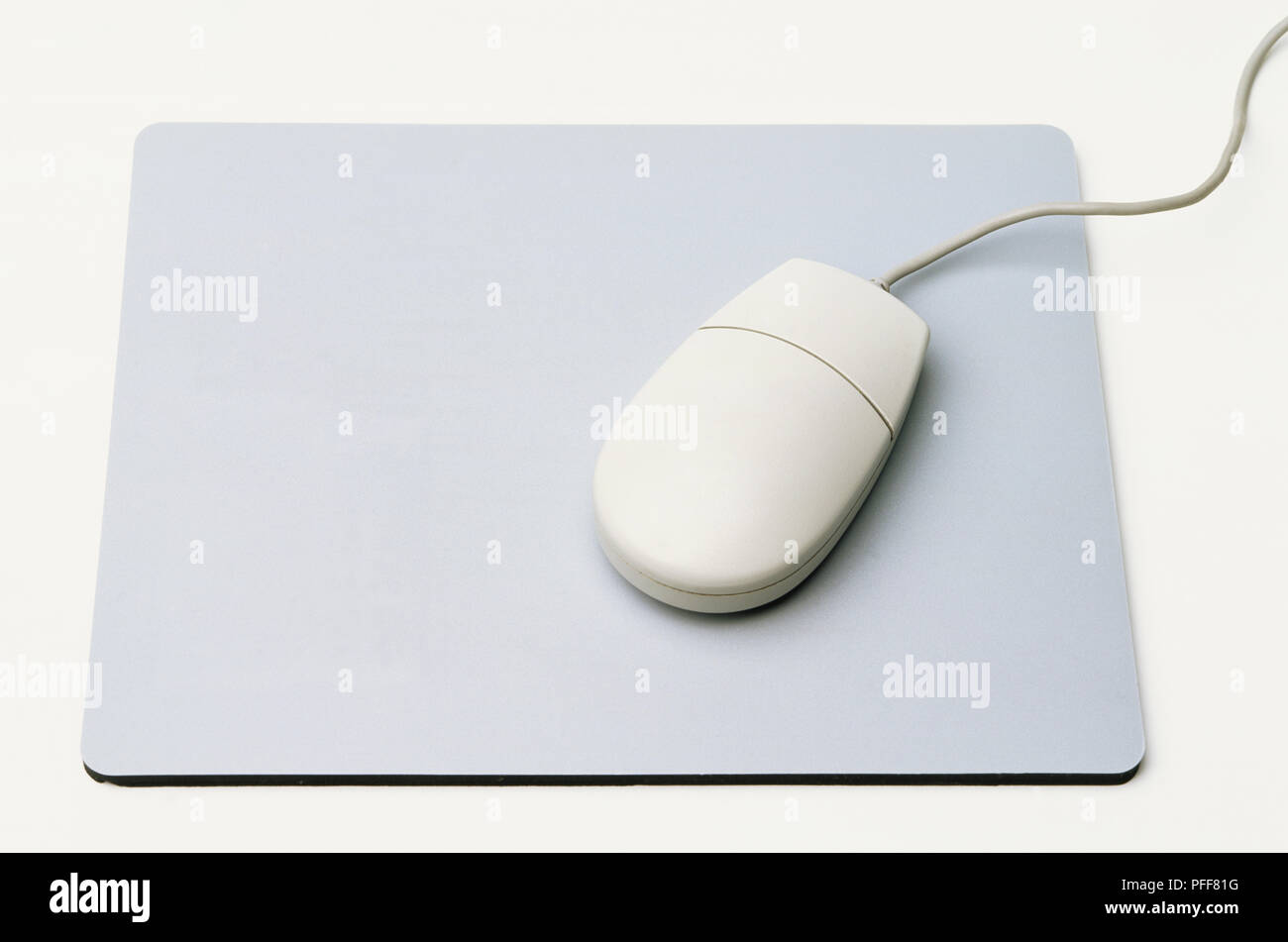 Computer mouse resting on mouse mat with integrated calculator, front view. Stock Photo