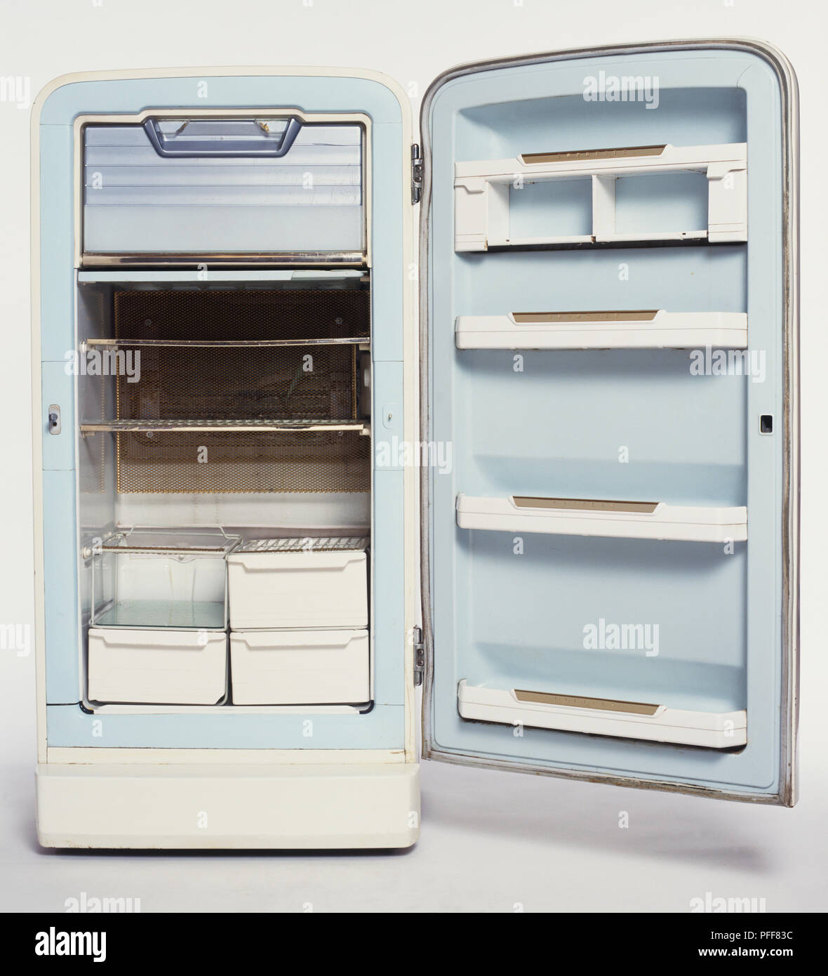 Empty 1950s fridge with its door wide open, front view. Stock Photo