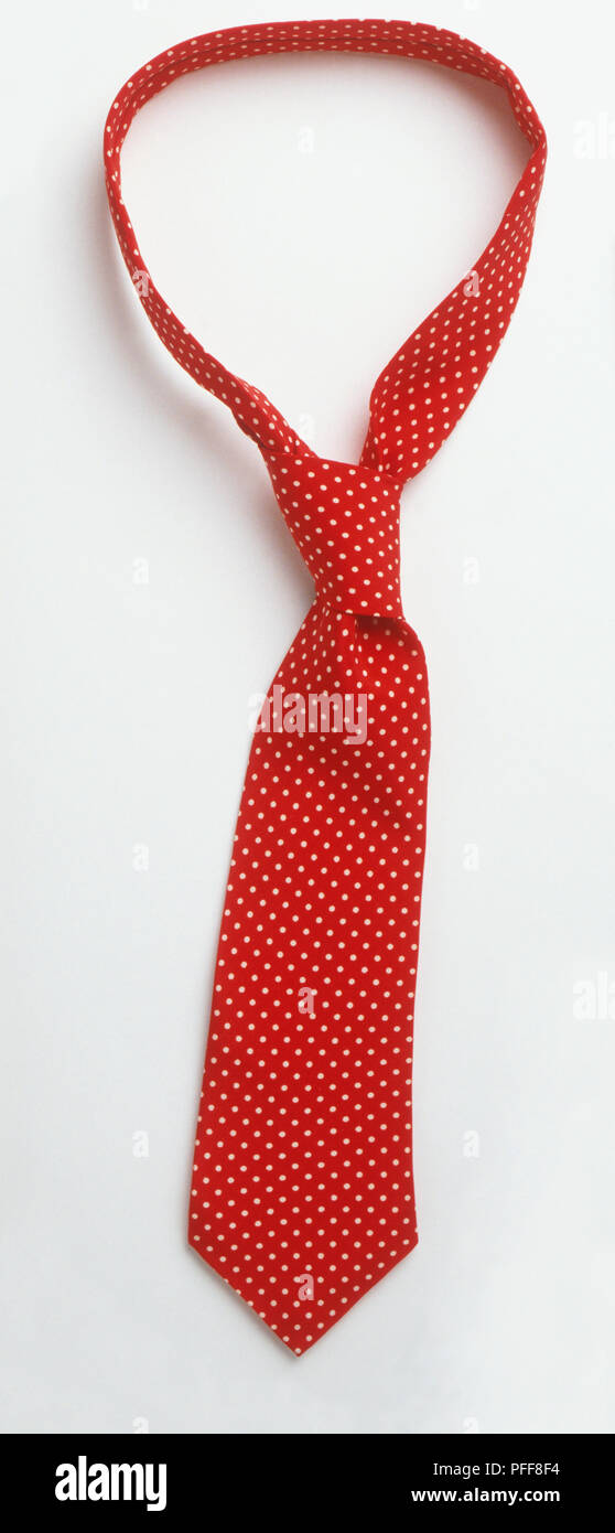 Knotted red tie with a pattern of small white dots Stock Photo