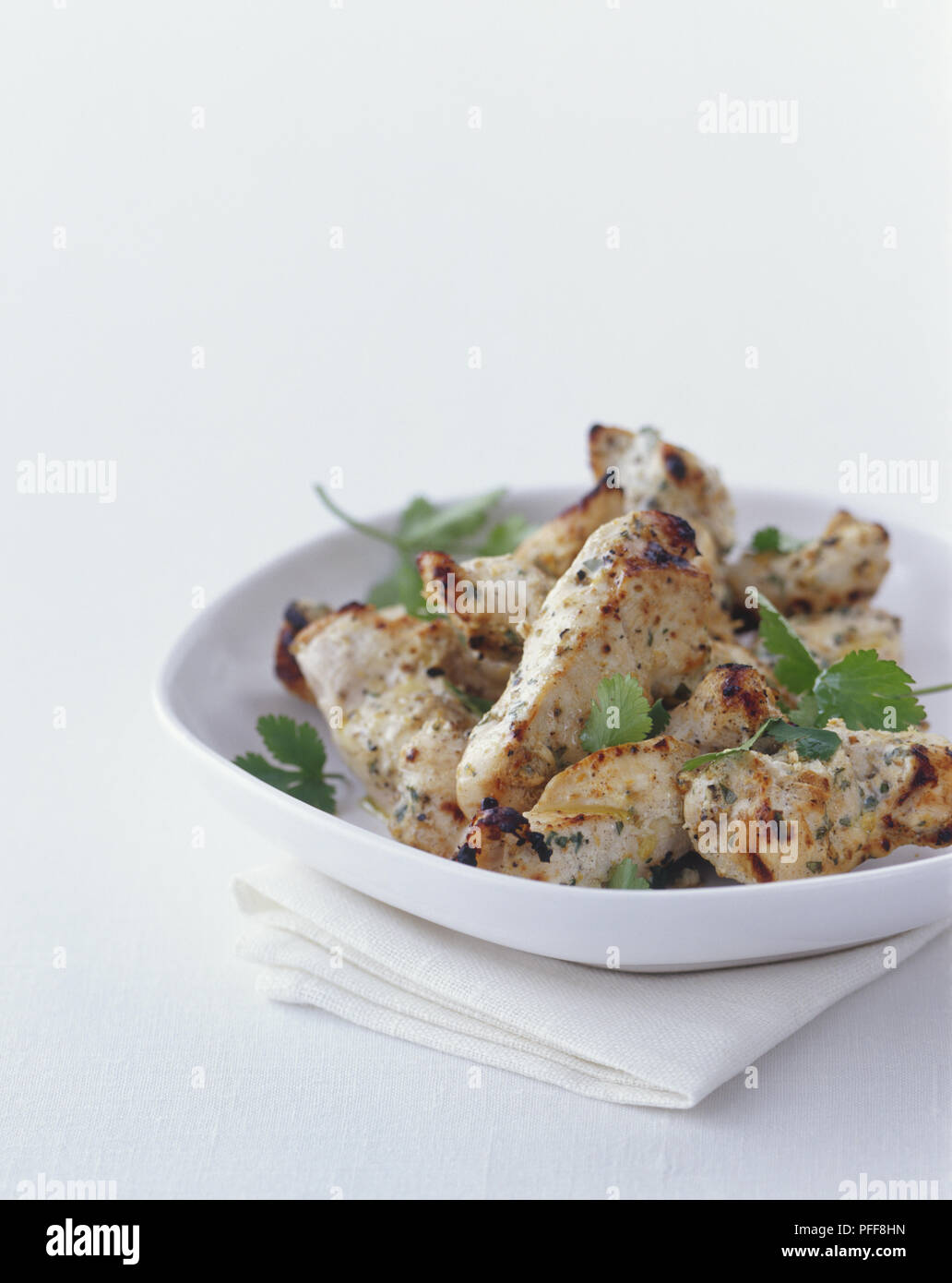 Coriandermarinated chicken kebabs garnished with fresh herbs Stock