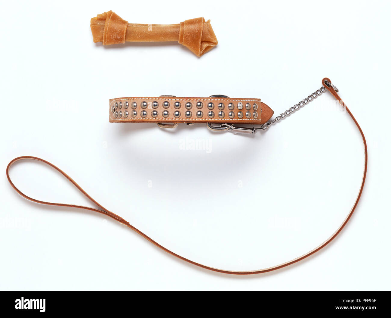 A dog's toy bone and a studded collar with leash Stock Photo