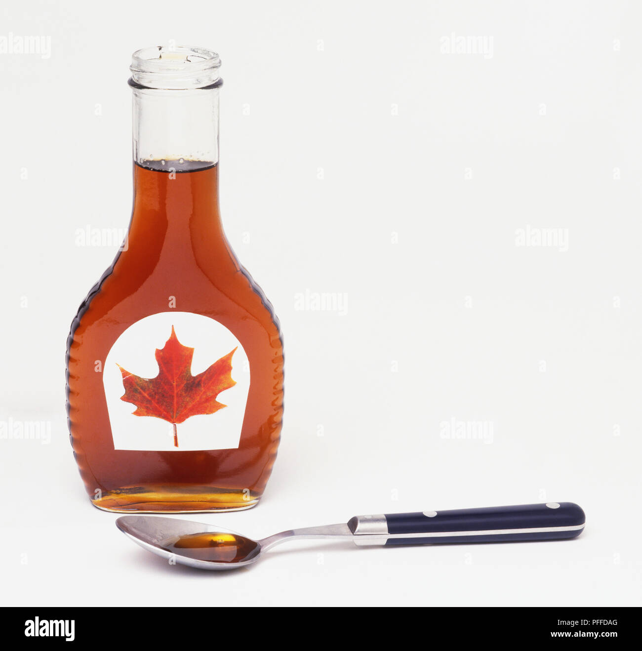 Bottle of maple syrup and spoonful of syrup Stock Photo Alamy