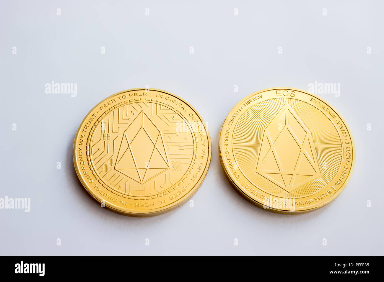 On a white background is isolated the front and back side of gold coin of a digital crypto currency - eos Stock Photo