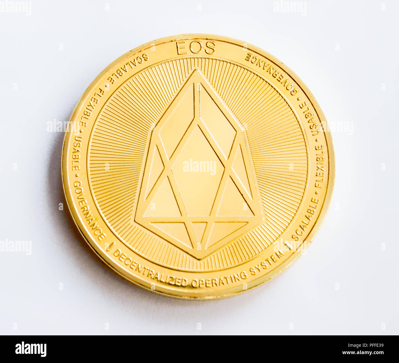 On a white background is isolated gold coin of a digital crypto  currency - eos. The front side of the gold coin eos. Stock Photo