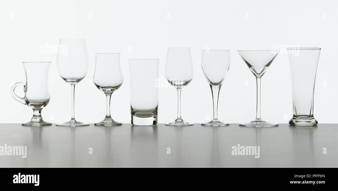 Eight different drinking glasses in a row, including stemware and